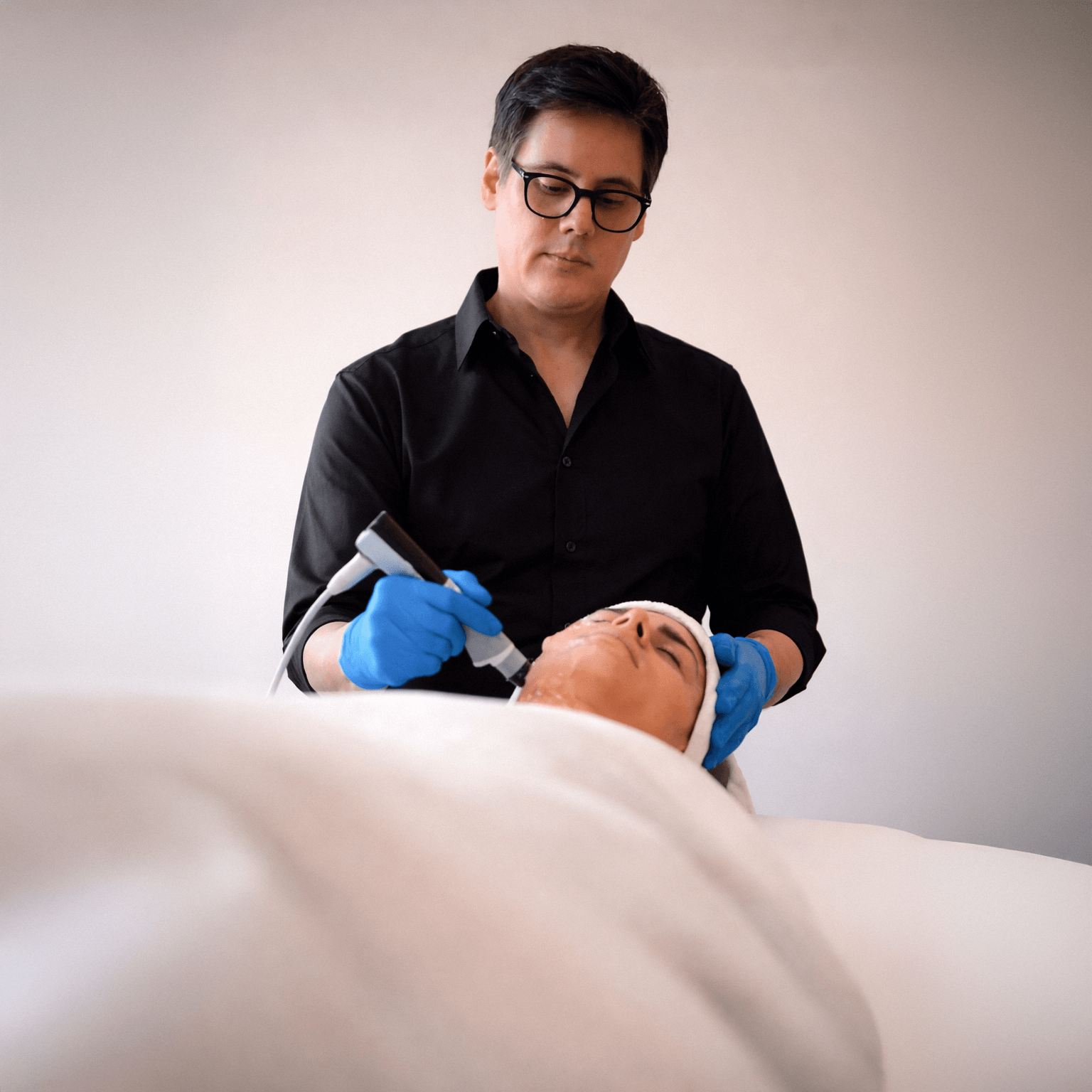 Person receiving an Exion treatment with a device held by a professional Aesthetic Doctor in a clinical setting.