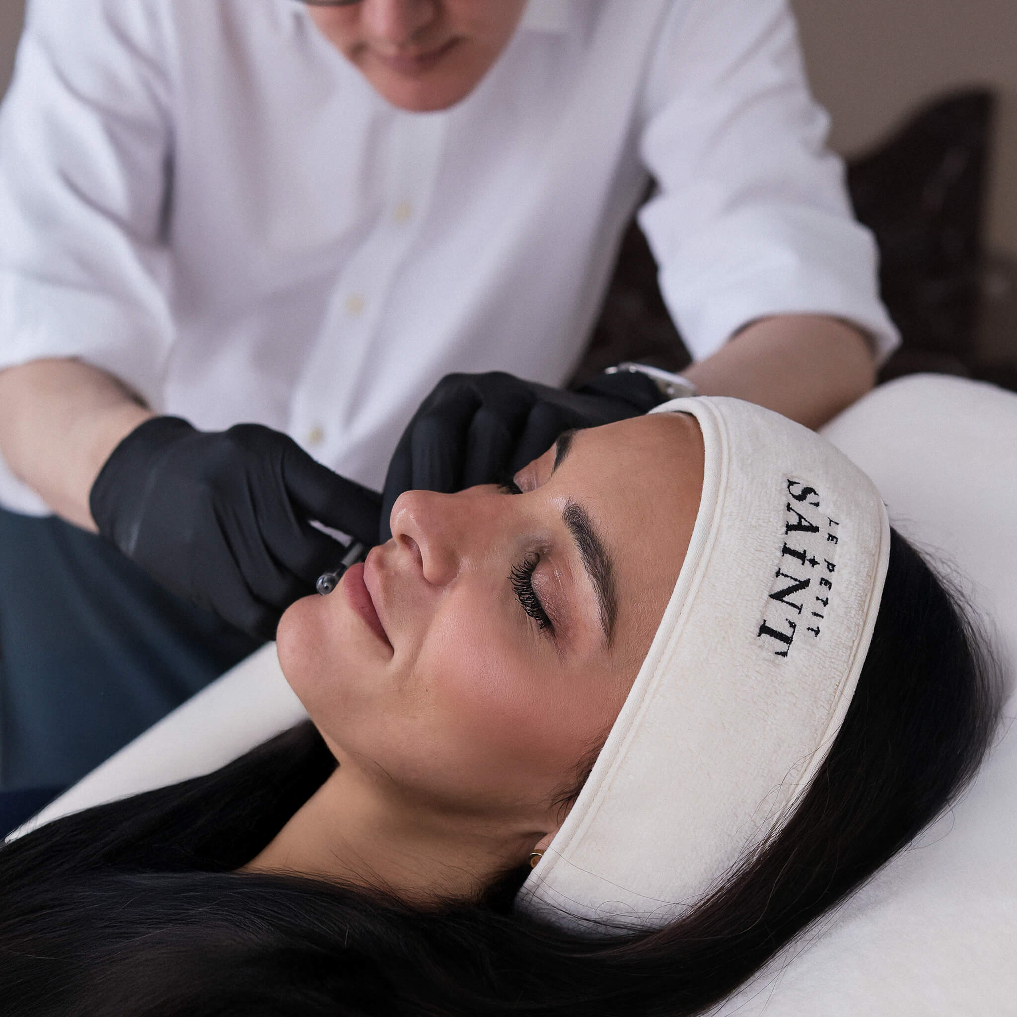 Injectables being administered calmly by our Medical Director Dr Raul Cetto on a woman's face. She looks relaxed and at peace. 