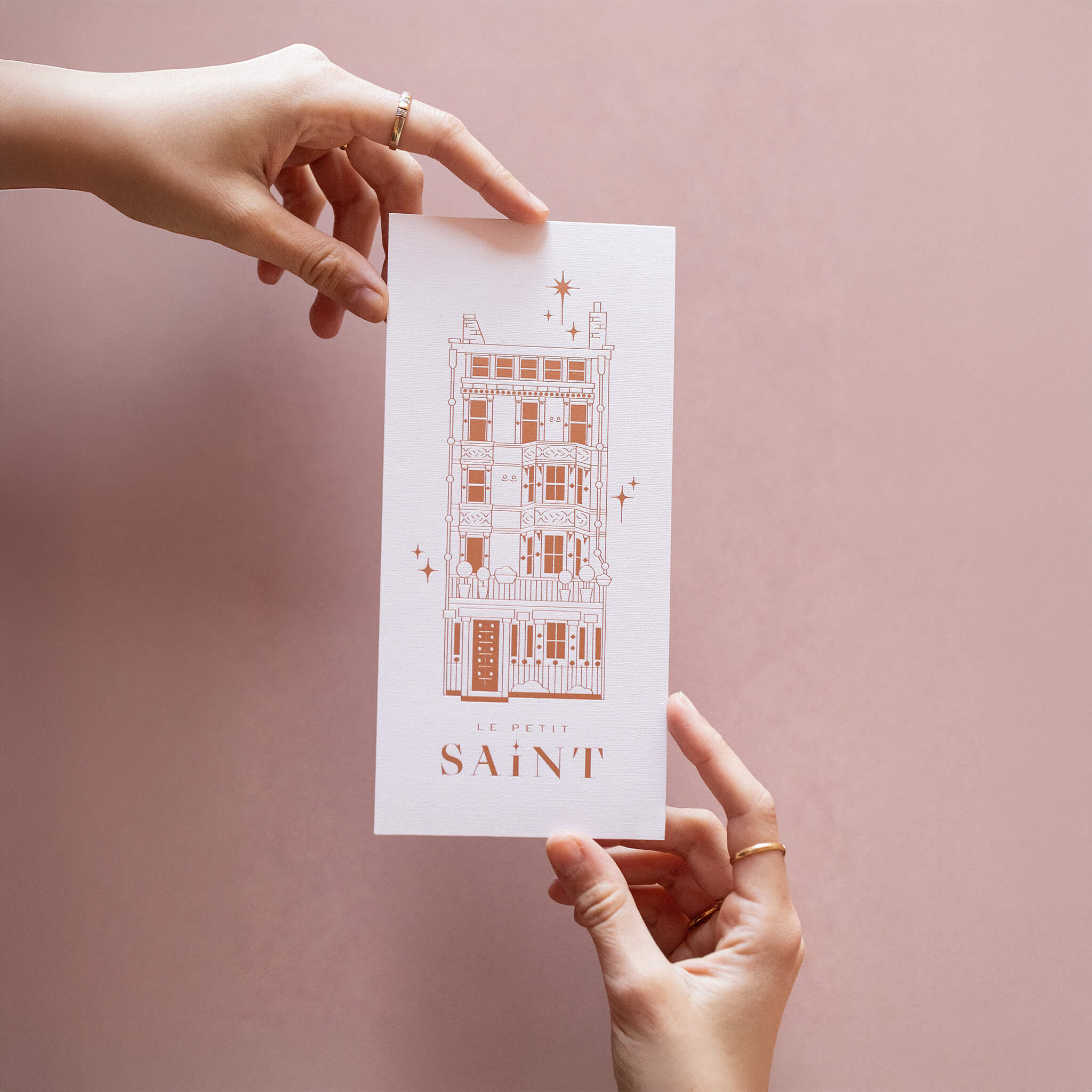 Two hands holding a Le Petit Saint  Gift Certificate - an Aesthetic Skin Clinic Mayfair London