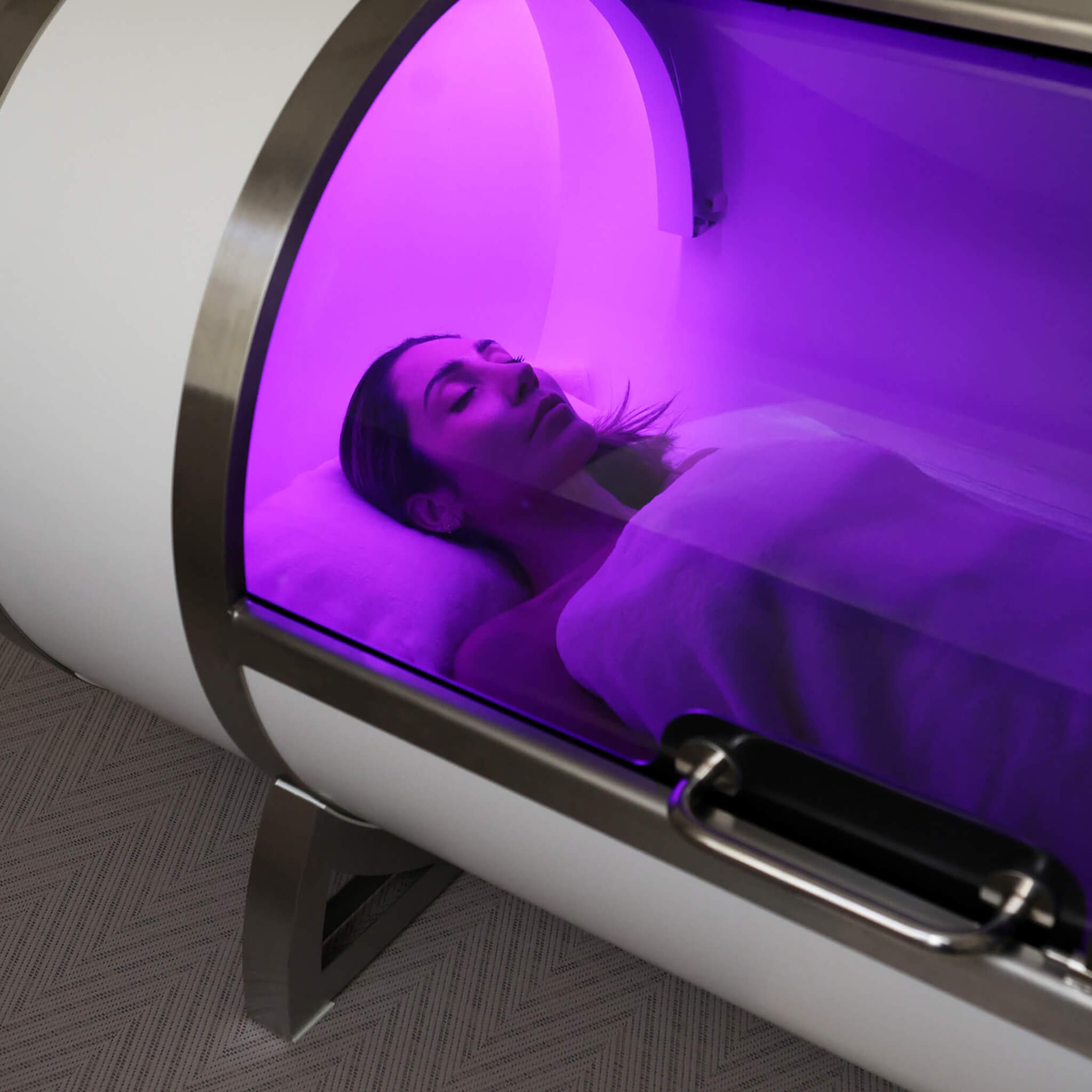 Person lying inside a Wellness Hyperbaric chamber at Le Petit Saint.