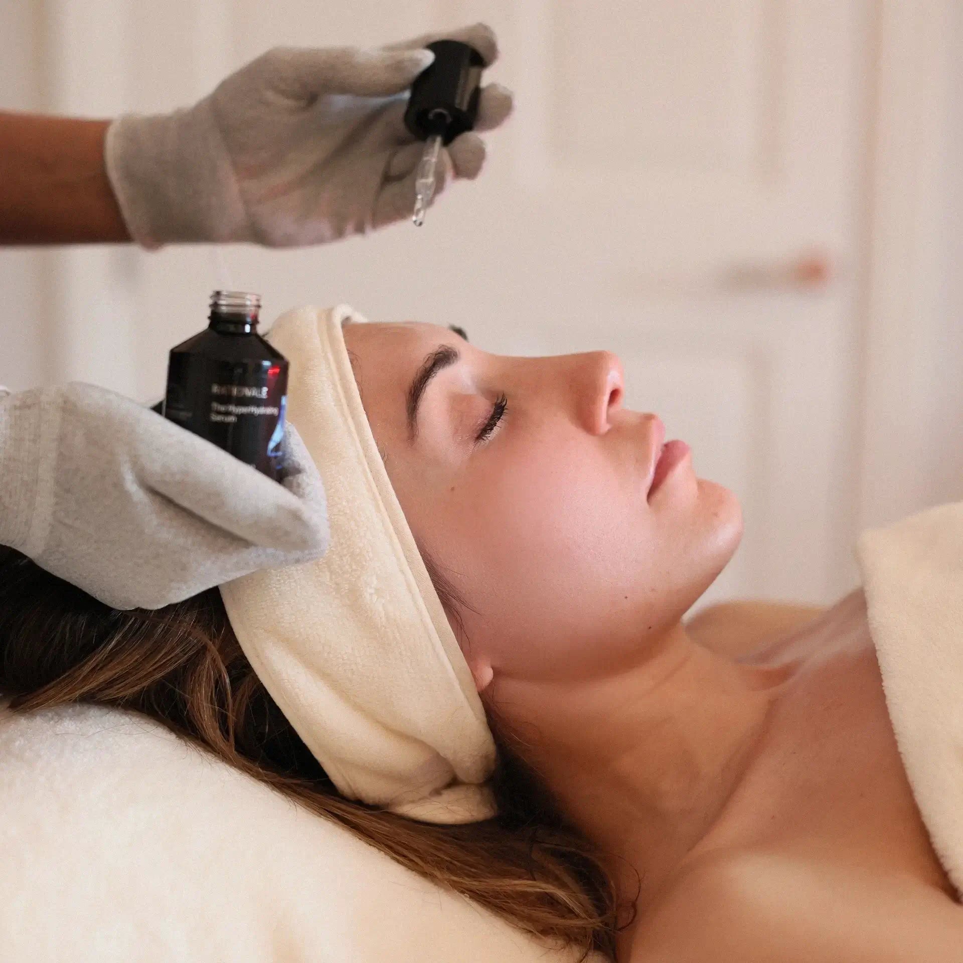 Woman receiving a rationale facial treatment with a professional skincare product being applied.