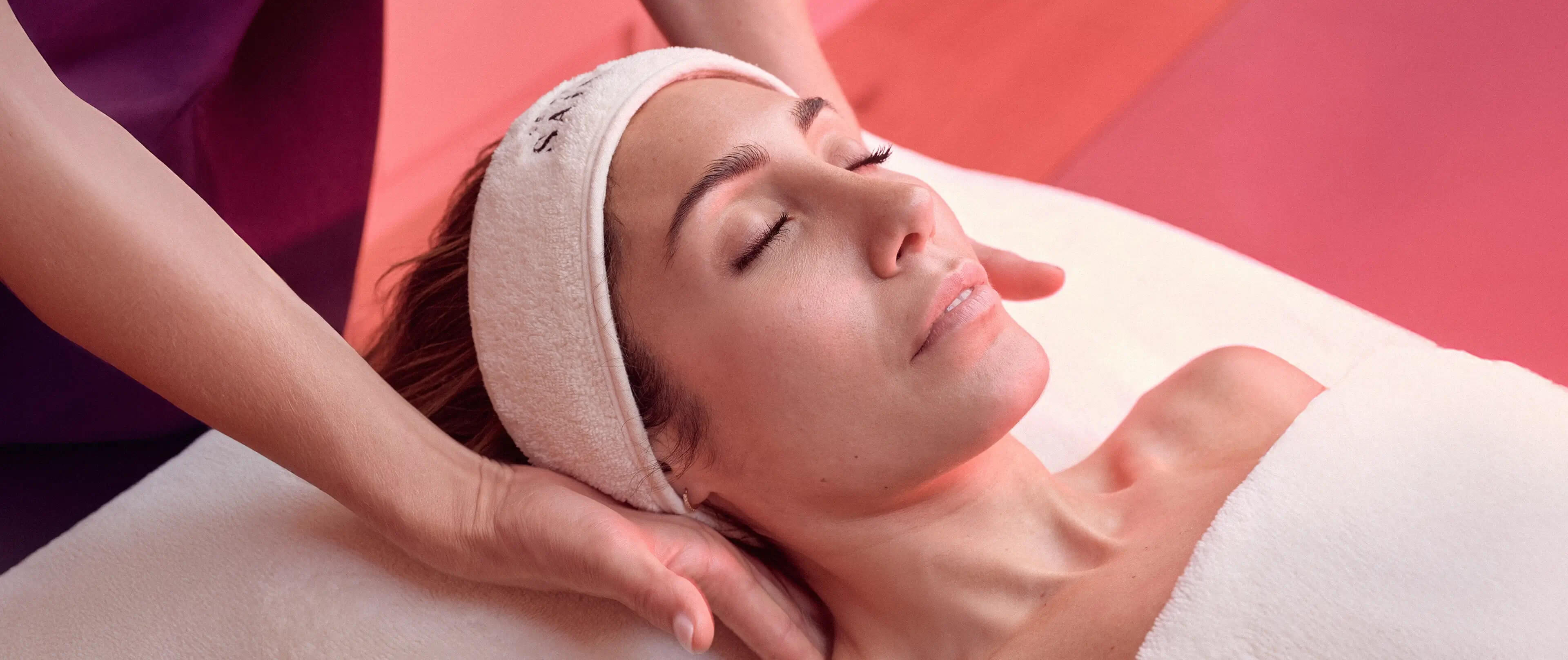 Woman receiving a facial treatment with a pink background, followed by a clinic room with a facial treatment table at Le Petit saint Clinic in mayfair London.
